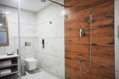 a bathroom with a shower with a wooden wall at The TeaTree Munnar in Suryanelli
