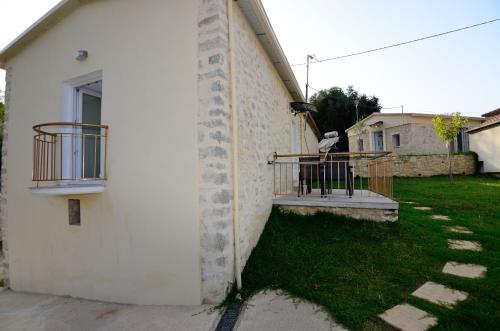 a white building with a balcony and a yard at Villas 1850 in Elefthérion