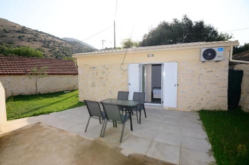 a patio with a table and chairs in a backyard at Villas 1850 in Elefthérion