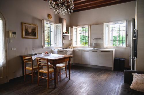 a kitchen with a table and chairs and windows at Casa Luisa in Lesignana