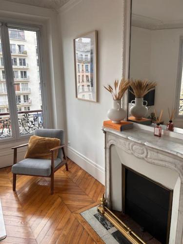 - un salon avec une cheminée et une chaise dans l'établissement Superbe appartement Paris 17ème 55m2, à Paris