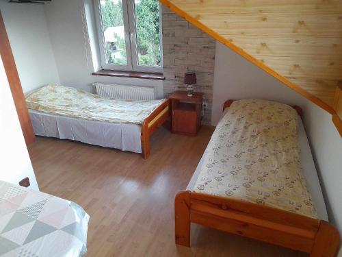 a bedroom with two beds and a stair case at Noclegi u Daszyka in Polańczyk