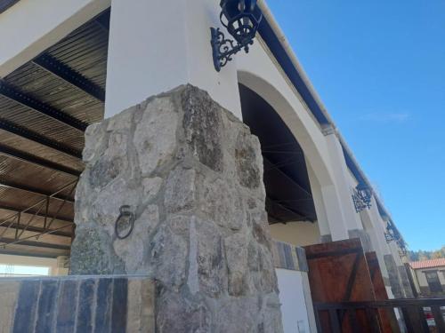 a stone pillar in a church with a cross at Hotel Quinta Mision in Creel