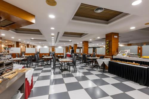 a restaurant with a checkered floor and tables and chairs at Hotel Casanova in Fraga