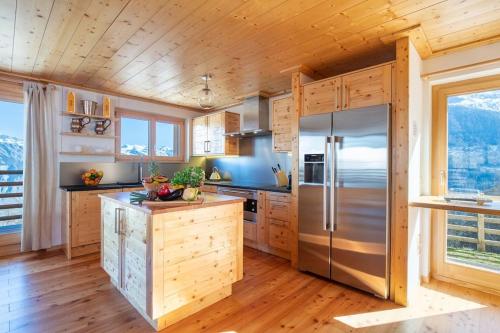 a kitchen with a refrigerator and wooden walls at Swiss Chalet Skyfall in La Tzoumaz