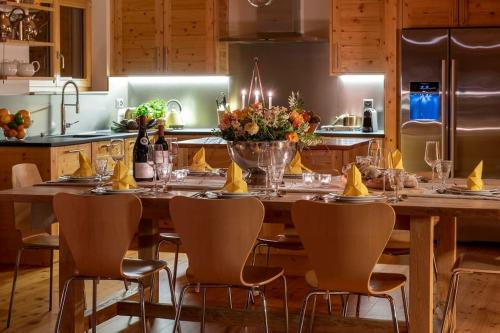 a kitchen with a large wooden table with chairs at Swiss Chalet Skyfall in La Tzoumaz