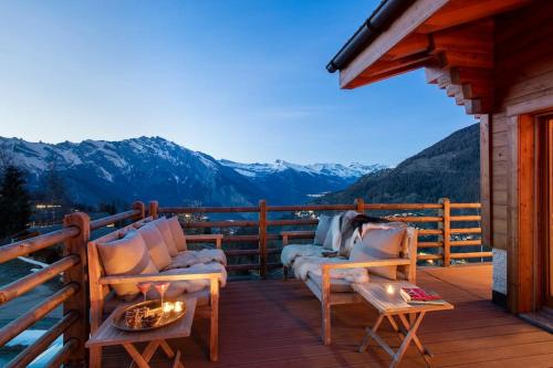 a deck with chairs and a fire pit on a mountain at Swiss Chalet Skyfall in La Tzoumaz