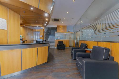 a waiting area in a hospital with chairs and a bar at Hotel Casanova in Fraga