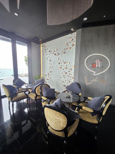 a dining room with tables and chairs and a wall with a painting at The Central Pattaya High Floor, Pattaya City in Pattaya Central