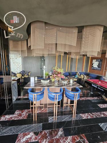 a dining room with a table and blue chairs at The Central Pattaya High Floor, Pattaya City in Pattaya Central