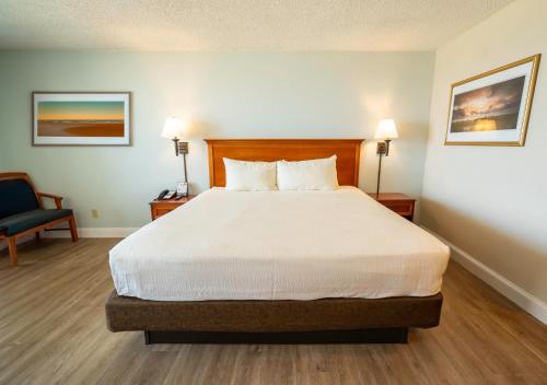 a hotel room with a bed and a chair at The Oceanfront Inn - Virginia Beach in Virginia Beach
