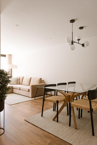a living room with a table and chairs and a couch at Souto Village - by RowdHouses in Maureles