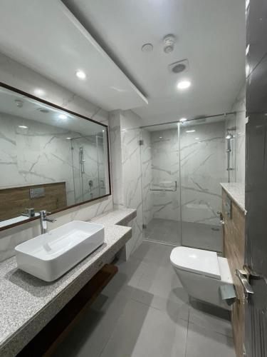 a bathroom with a sink and a toilet and a shower at Penta Square Apartments - PK LHR in Lahore