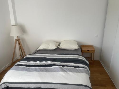 un lit avec deux oreillers dessus dans une chambre dans l'établissement MIchelet st jacques saxo, à Marseille