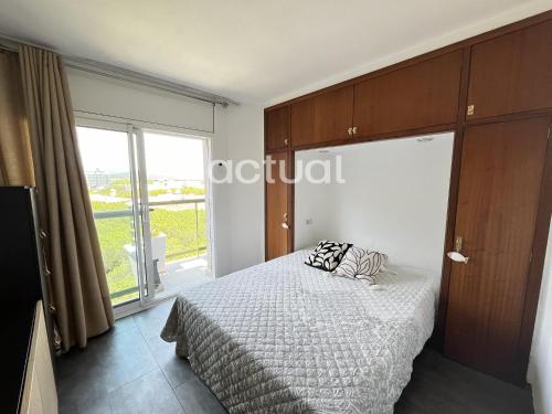 Un dormitorio con una cama y una ventana grande. en Fanals 4M, en Platja d'Aro