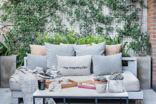 a couch on a patio with books and plants at Casa Chic Palermo Hotel Boutique in Buenos Aires