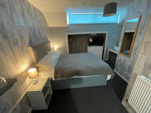 a small bedroom with a bed and a mirror at The Sefton Blackpool in Blackpool
