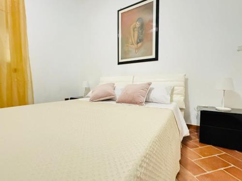 a bedroom with a white bed with pink pillows at Villa Ginevra in Taranto