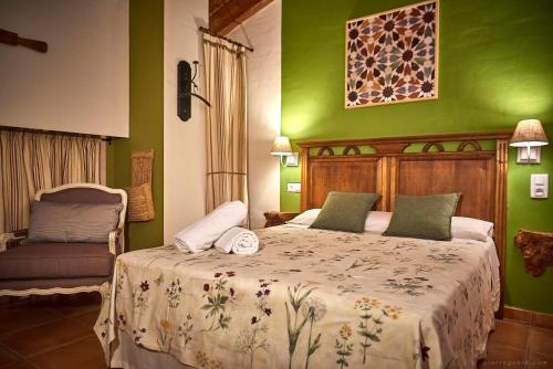 a bedroom with a bed with green walls at Cortijo De Ramón in Cortijos Nuevos