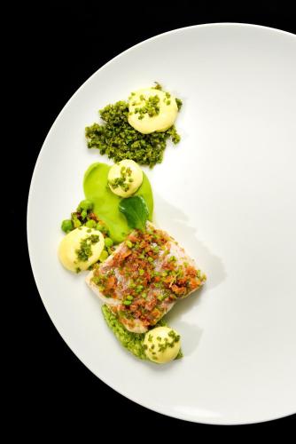 une plaque blanche contenant du poisson et des légumes dans l'établissement Ar Men Du, Hôtel & Restaurant Gastronomique, à Névez