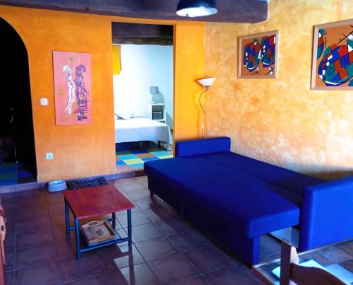 a living room with a blue couch and a bed at LOS ORIZOS Sierra de Gata Extremadura TR-CC-00392 in Villamiel