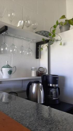 a kitchen counter with a coffee pot on a stove at Recanto Roseiral - Casa Campo in Feliz
