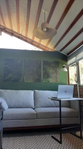 a living room with a couch and a laptop on a table at Recanto Roseiral - Casa Campo in Feliz