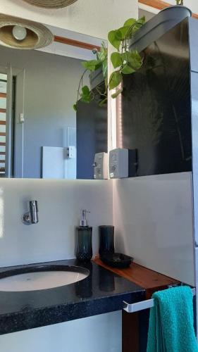 a bathroom counter with a sink and a mirror at Recanto Roseiral - Casa Campo in Feliz