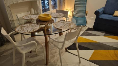 un salon avec une table en verre et des chaises dans l'établissement Maison Carnot, à Cannes