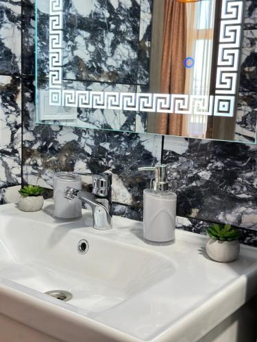 a bathroom sink with two soap dispensers on it at Apartments Black Sea in Odesa