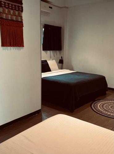 a bedroom with two beds and a mirror at Holland Lodge Paramaribo in Paramaribo