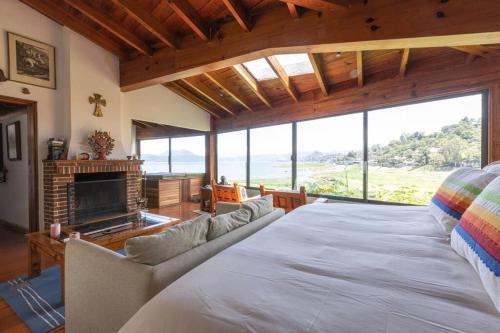 バジェ・デ・ブラボにあるCozy Cabin in Avandaroの大きなベッドと暖炉のある寝室