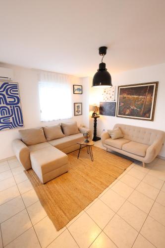 a living room with two couches and a rug at Sailors Lodge - 3 min to beach in Pula