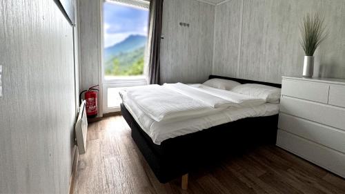 a bed in a room with a large window at Mjøsvang Kafe in Vang I Valdres