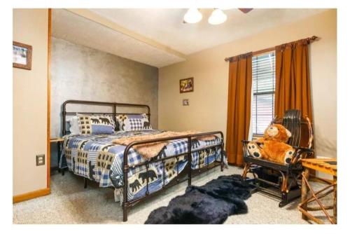 Un dormitorio con una cama y una silla y una ventana. en Riverside Dreamin, en Sevierville