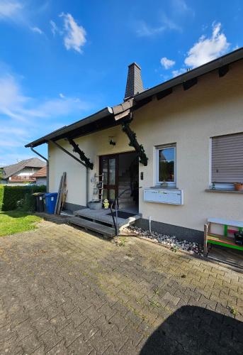 a white house with a window and a patio at Haus des Schneiders in Büchenbeuren