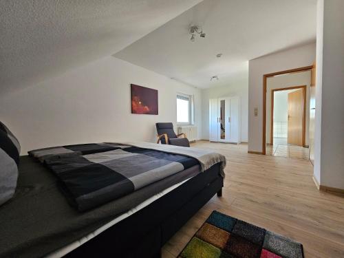 a bedroom with a bed and a chair in it at Haus des Schneiders in Büchenbeuren
