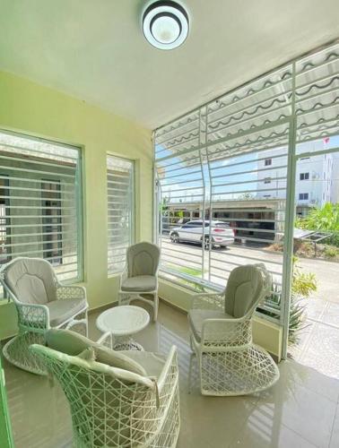 a room with chairs and a table and windows at Elegante y acogedora casa espaciosa in SJM