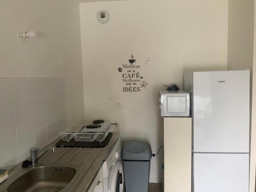 une petite cuisine avec un évier et un réfrigérateur dans l'établissement Appartement cosy à Alforville avec Parking, à Alfortville