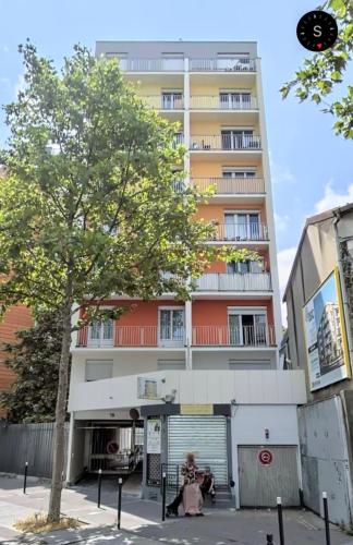 une femme assise devant un grand immeuble dans l'établissement Studio D Paris, à Aubervilliers