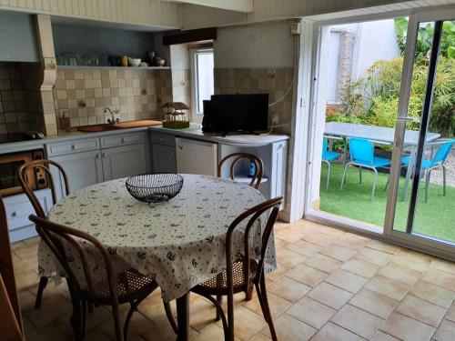 Il dispose d'une cuisine avec une table et des chaises. dans l'établissement Jardin clos et calme, vélos à disposition, plages à 2 kms, à Tréffiagat
