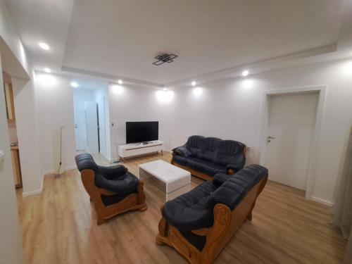 a living room with two couches and a flat screen tv at Apartman Aldijana in Ripač