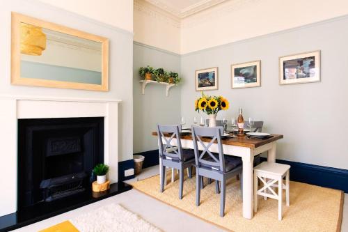 a dining room with a table and chairs and a fireplace at Air Maison - Shore Stay in Portsmouth
