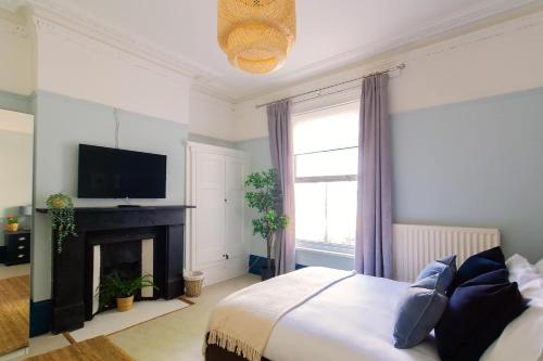 a bedroom with a bed with a fireplace and a television at Air Maison - Shore Stay in Portsmouth