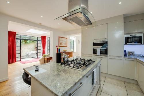 a kitchen with a stove and a counter top at Wildflower Garden - Spacious Garden Apartment in Portsmouth