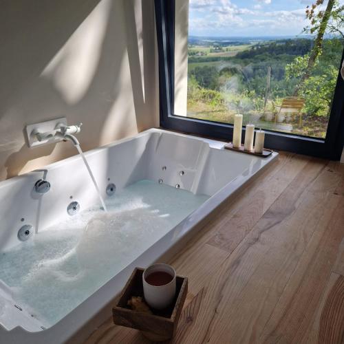 une baignoire dans une salle de bain avec une fenêtre dans l'établissement Casa Sirra, à Saint-Germain-des-Prés
