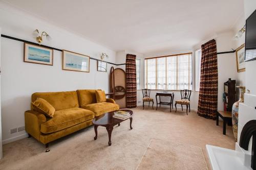 a living room with a couch and a table at Wildflower Garden - Spacious Garden Apartment in Portsmouth