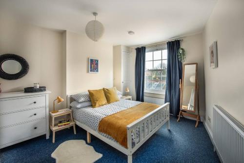 a bedroom with a bed and a dresser and a window at Air Maison - St Jude's View in Portsmouth
