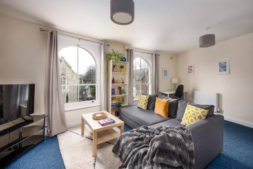 a living room with a couch and a tv at Air Maison - St Jude's View in Portsmouth