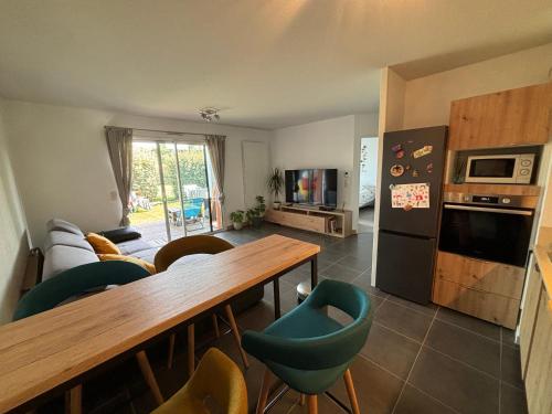 une cuisine avec une table et quelques chaises dans une pièce dans l'établissement Appartement au calme à 10min des plages - avec Rez de Jardin et Terrasse, à Bénesse-Maremne